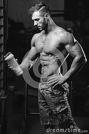 Muscular Man Resting After Exercise And Drinking From Shaker Stock Photo