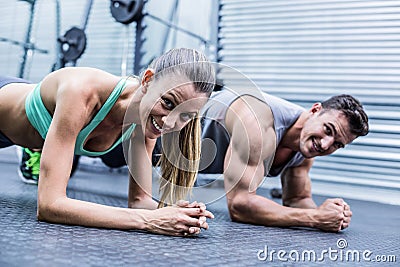 Muscular couple doing planking exercises Stock Photo