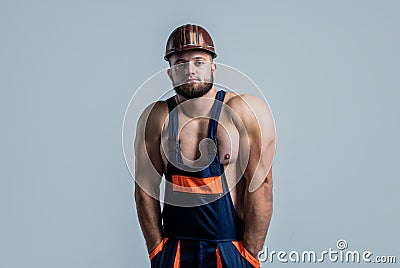 Muscular man architect with strong body. guy wear worker uniform. athletic builder in helmet. sexy man with body muscles Stock Photo