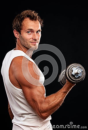 Muscular man lifting dumbbell Stock Photo