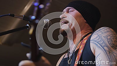 Muscular man musician plays guitar at rock-concert Stock Photo