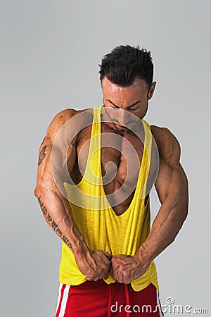 Muscular man pulling down tanktop on torso Stock Photo