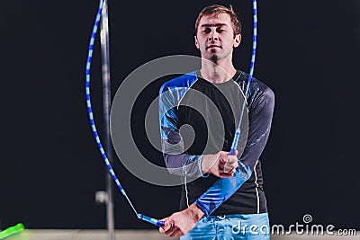 Muscular man skipping rope. Portrait of muscular young man exercising with jumping rope on black background. Stock Photo