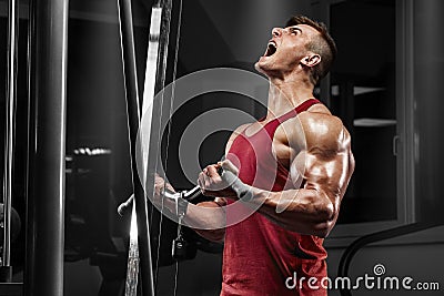 Muscular man working out in gym doing exercises, strong male Stock Photo