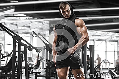 Muscular man working out in gym doing exercises, strong male bodybuilder Stock Photo