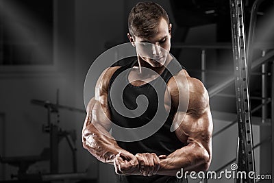 Muscular man working out in gym. Strong male showing muscles biceps Stock Photo