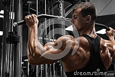 Muscular man workout in gym, doing exercise for back. Strong male rear view Stock Photo