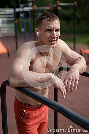Confident sportsman leaning on handrail at park Stock Photo