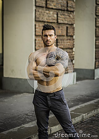 Muscular shirtless man in city centre Stock Photo