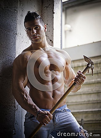 Muscular shirtless young man with farming tool Stock Photo