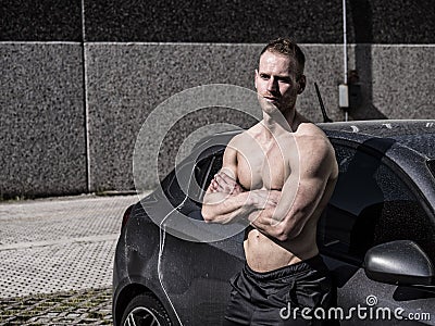 Muscular topless man outside of car Stock Photo