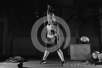 Muscular young fitness woman lifting a weight in the gym Stock Photo