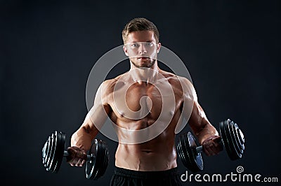 Muscular young man lifting weights on black background Stock Photo