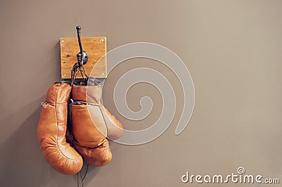 Museum of box sport. Box exhibition retro attributes. Boxing school. Vintage boxing gloves hang on hook wall background Editorial Stock Photo