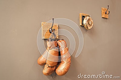 Museum of box sport. Box exhibition retro attributes. Boxing school. Final sparring. Vintage boxing gloves hang on hook Editorial Stock Photo