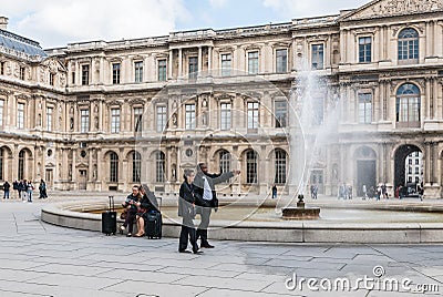 Museum workers and tourists near fountain at Louvre Editorial Stock Photo