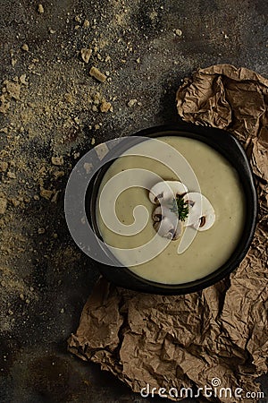 Mushroom soup with 3 mushrooms on top on rusty brown background and wrinkled texture Stock Photo