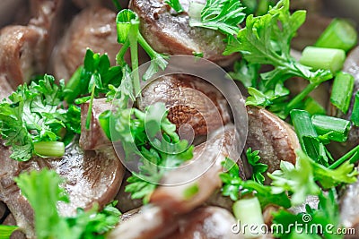 Mushrooms champignons stewed in sour cream sauce with green parsley, close-up, selective focus Stock Photo