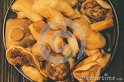 Mushrooms on plate. Pickled mushrooms in a plate. On wooden background Stock Photo