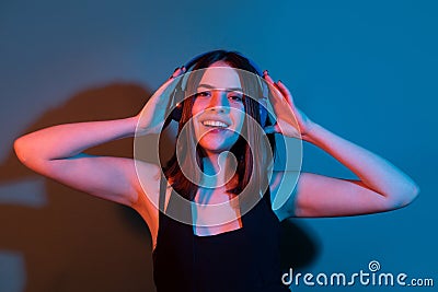 Music, emotions concept. Carefree woman dances in rhythm of melody, closes eyes listens song in headphones, dancind Stock Photo
