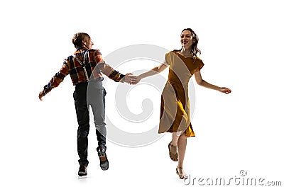 Dynamic portrait of stylish dancers, young man and woman in vintage attire dancing swing isolated on white background Stock Photo