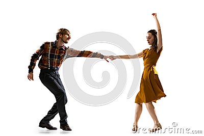 Dynamic portrait of stylish dancers, young man and woman in vintage attire dancing swing isolated on white background Stock Photo