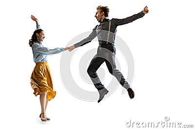 Dynamic portrait of stylish dancers, young man and woman in vintage attire dancing swing isolated on white background Stock Photo