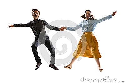 Dynamic portrait of stylish dancers, young man and woman in vintage attire dancing swing isolated on white background Stock Photo