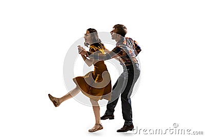 Dynamic portrait of stylish dancers, young man and woman in vintage attire dancing swing isolated on white background Stock Photo