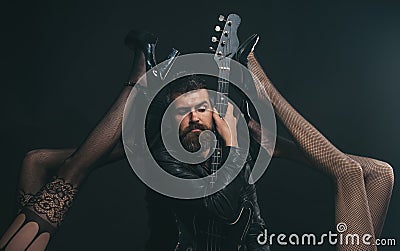 Music is his passion. Bearded man with guitar tempted by legs in fetish lingerie. Feeling flirty. Like rock star Stock Photo