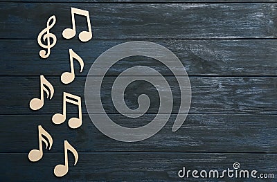 Music notes and treble clef on wooden background, top view. Stock Photo