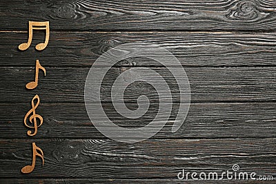 Music notes and treble clef on wooden background, top view. Stock Photo