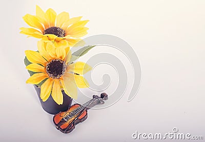 Music passion and hobby concept, violin miniature with artificial flower plant on reflection white table Stock Photo