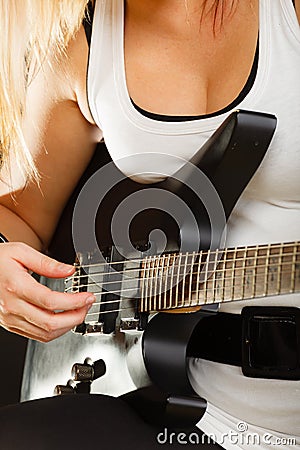 Woman playing on electric guitar, black background Stock Photo