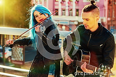Music street performers with girl violinist sunset cityscape. Stock Photo