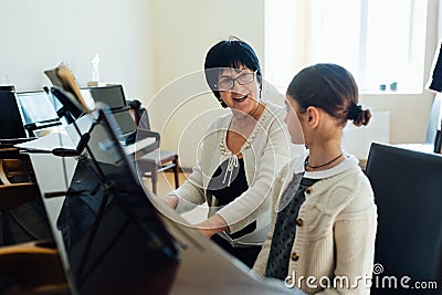 Music teacher explains gleefully how to play piano Stock Photo