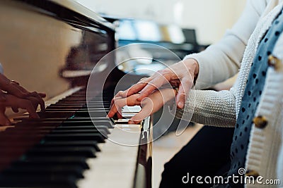 Music teacher helps student to play correctly Stock Photo