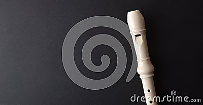 Musical background with detail of white plastic recorder on black Stock Photo