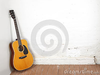 Musical instrument - Classic acoustic guitar white brick background Stock Photo