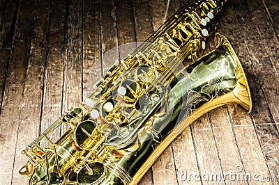 part of the case tube with pockets and bells of a yellow saxophone on an old wooden surface Stock Photo