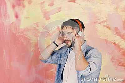 Musical lifestyle. Blue eyed stylish hipster with smartphone. American handsome bearded guy with headphones. Stock Photo