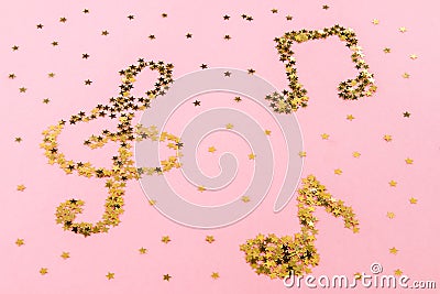 Musical notes of starry golden confetti lying on a pink pastel background. Stock Photo