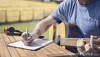 Musician guitarist playing acoustic guitar and writing music Stock Photo