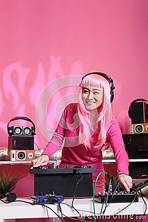 Musician performer playing electronic song using professional turntables at night in club Stock Photo