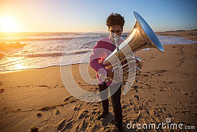 Musician play to musical instrument Tuba on ocean shore. Hobby. Stock Photo