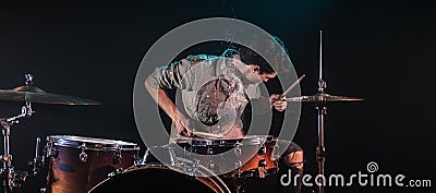 Musician playing drums with splashes, black background with beautiful soft light Stock Photo