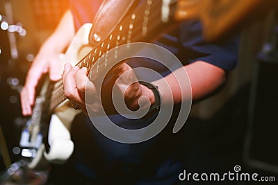 Close up hand young man playing electric guitar at recording studio rehearsal base. rock music band Stock Photo