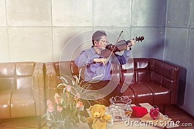 Musician playing violin in living room relax time. Stock Photo