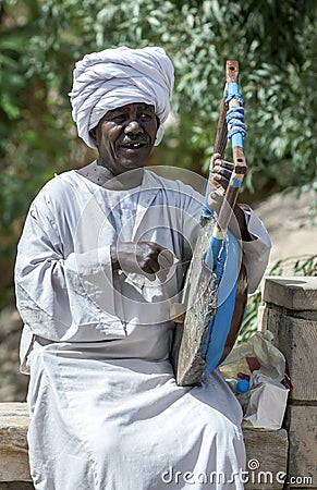 A musician plays an Egyptian guitar for tourists at Philae in Egypt. Editorial Stock Photo