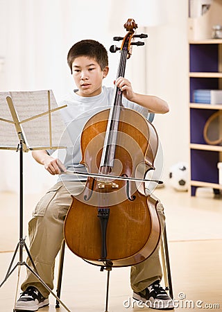 Musician practices performing on cello Stock Photo